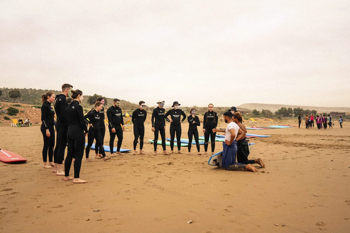 Beginner surfer paddling out at a sandy beach break on the Moroccan Atlantic coast
